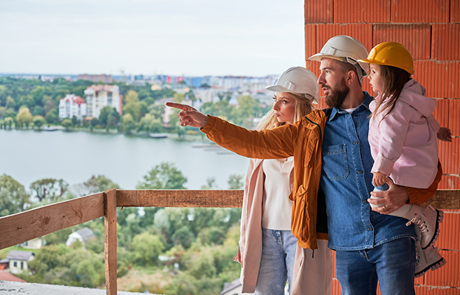Hausbau Ratgeber Titelbild mit einer Familie die in die Zukunft Blick stehend auf ihrer Baustelle