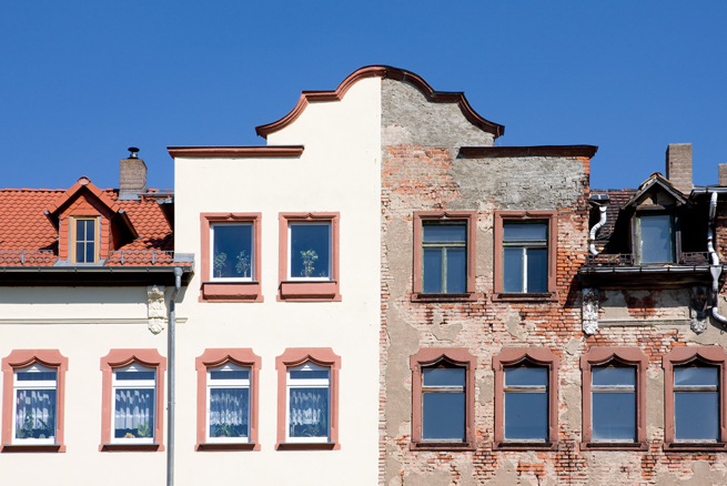 Gebäude welches zur Hälfte saniert und modernisiert ist mit neuen Fenstern