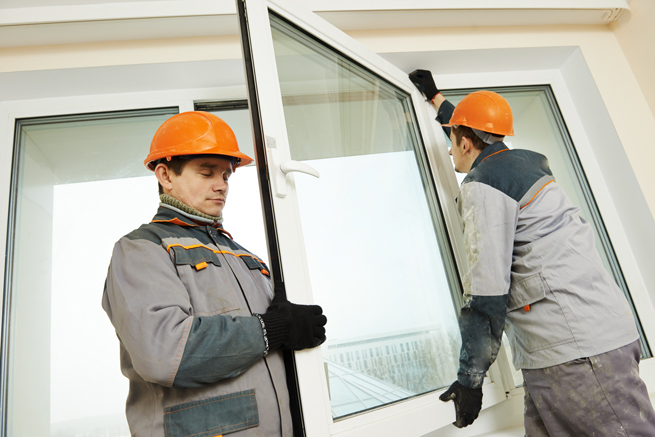Fenstereinbau nach RAL Norm durch zwei Handwerker die einen Flügel am Fenster montieren
