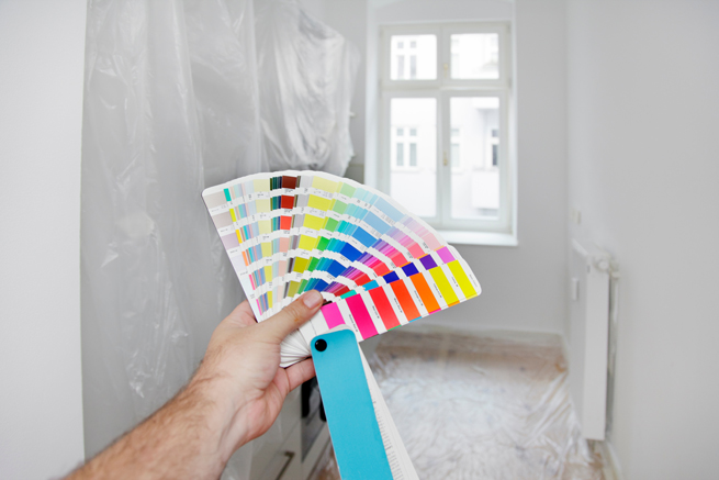 Hand mit einem Farbfächer zur Wahl der richtigen Farbe
