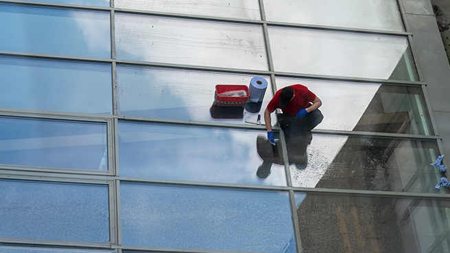 Reinigungsdienst reinigt aussen die Sicherheitsglasscheiben am Hochhaus