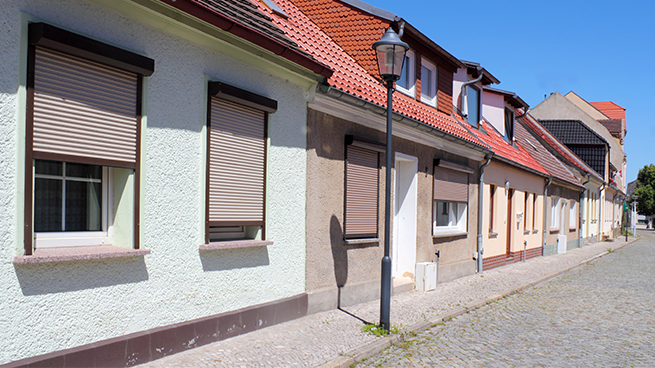 Différentes maisons d'habitation avec des volets roulants non sécurisés au premier étage donnant sur la rue