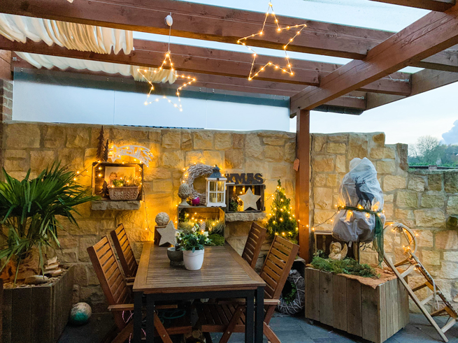 Schön geschmückte und eingerichtete Sitzecke auf Terrasse mit Weihnachtsschmuck