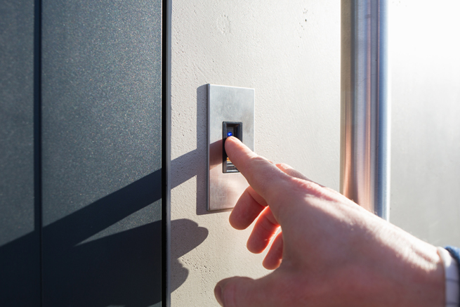 Hand die mit einem Fingerprint Sensor die Haustüre entsichert