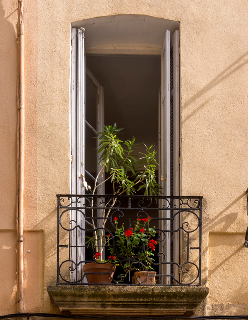 Ein französischer Balkon vor einem geöffneten bodentiefen Fenster