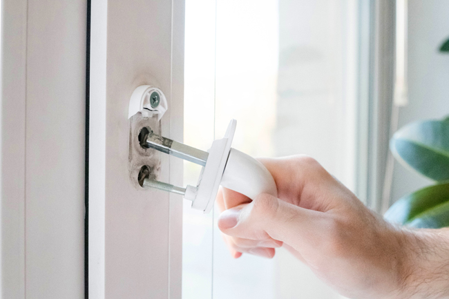 Ein abgebrocherer Fenstergriff wird aus dem Fenster herausgezogen