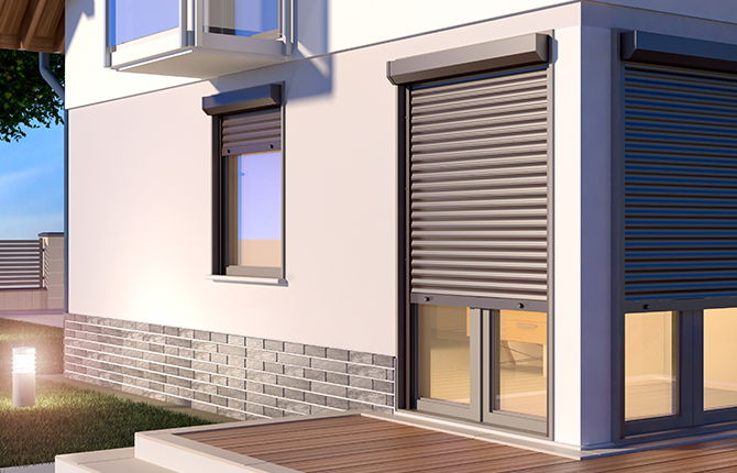 Arrière de la maison avec véranda et volet roulant extérieur semi-ouvert en couleur anthracite