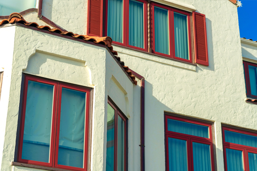 Fenêtres rouges sur une façade de maison claire