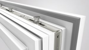 Ferrure de fenêtre de Roto sur le dessus d'une fenêtre en PVC blanc avec vue sur les galets champignons