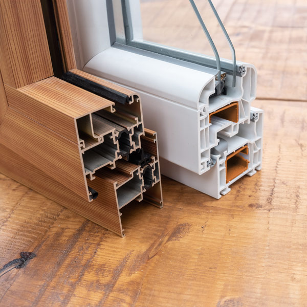 Kunststofffensterprofil und Aluminiumfensterprofil im Vergleich nebeneinander im Querschnitt