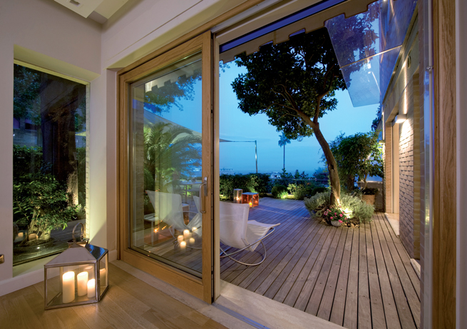 Offene Terrassentüre mit Blick auf eine von Kerzenschein beleuchtete Terrasse