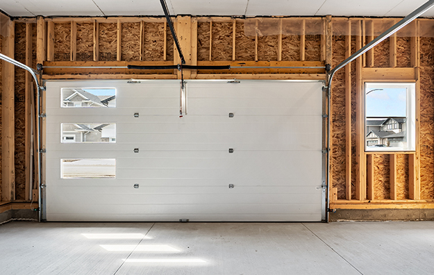 Porte de garage de domuteq avec 3 fenêtres sur un côté dans un garage en construction
